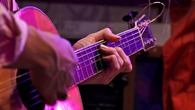 Man playing an acoustic guitar on stage 