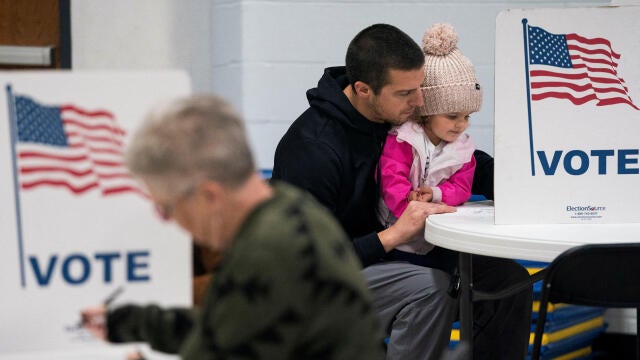 Dustin Ritchie, 34, votes with his daughter in the U.S. presidential election on Election Day at the Douglas County Central Assembly of God polling location in Superior, Wisconsin, Nov. 5, 2024. 