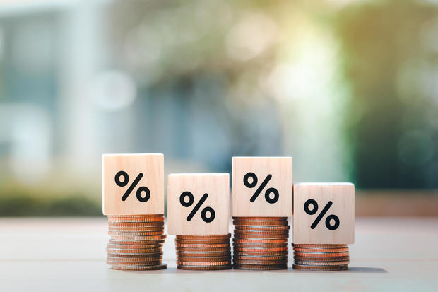 Interest rate finance and mortgage rates. Wooden block with percentage sign on many level of stack of coin. Financial growth, interest rate increase, inflation, sale price and tax rise concept. 