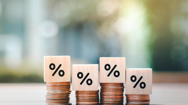 Interest rate finance and mortgage rates. Wooden block with percentage sign on many level of stack of coin. Financial growth, interest rate increase, inflation, sale price and tax rise concept. 