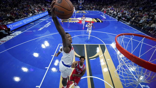 New York Knicks' OG Anunoby, left, goes up for a dunk past Philadelphia 76ers' Kyle Lowry during the second half of an Emirates NBA Cup basketball game, Tuesday, Nov. 12, 2024, in Philadelphia. 