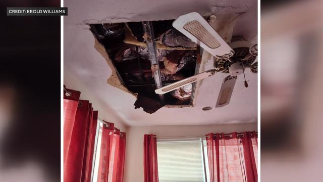 A large rectangular hole in a ceiling exposes beams and insulation. 