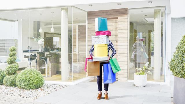 Woman hidden by her shopping bags and boxes 