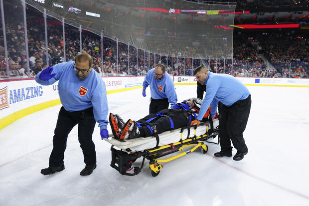 Referee Mitch Dunning is stretchered off the ice after an injury during the first period of an NHL hockey game between the Philadelphia Flyers and the Colorado Avalanche 