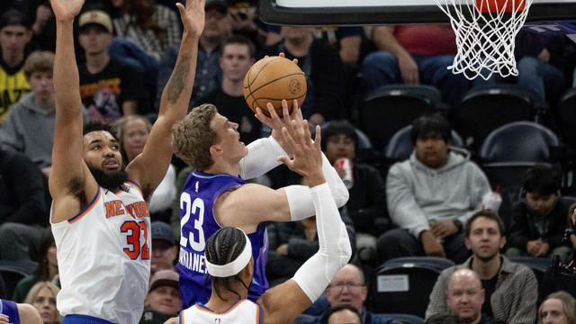 Utah Jazz forward Lauri Markkanen (23) goes to the hoop between New York Knicks center Karl-Anthony Towns, left, and guard Josh Hart during the first half of an NBA basketball game, Saturday, Nov. 23, 2024, in Salt Lake City. 