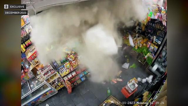 Surveillance video from inside a deli shows the ceiling and walls crumbling, sending dust and debris into the store. 