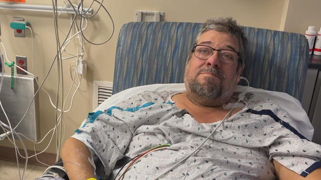 Kidney transplant recipient smiles at the camera from his hotel room 