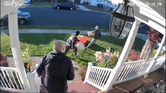 Porch camera video shows two individuals running away from a home with a package. 