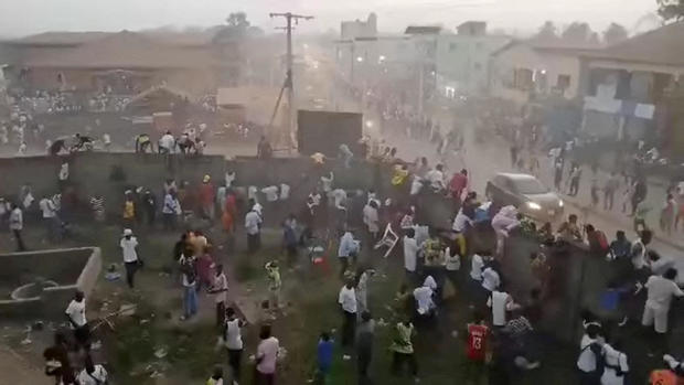 People scramble in Nzerekore where local officials said a crush occurred following clashes at a soccer match 