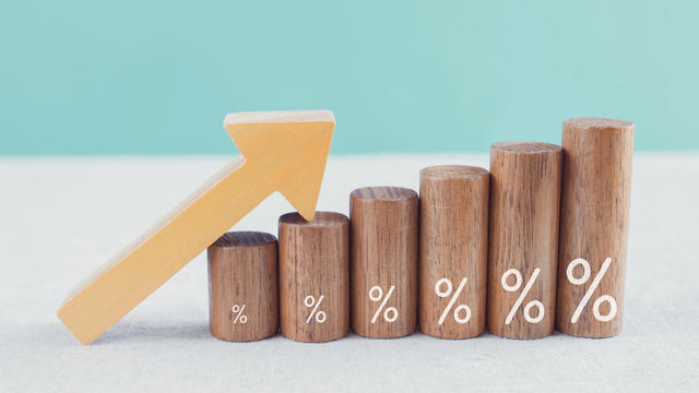 Wooden blocks with percentage sign and arrow up, financial growth, interest rate and mortgage rate increase, inflation concept 