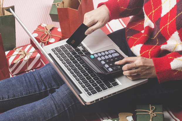 Christmas online shopping . Female buyer with laptop, prepare to xmas eve, sitting among gifts boxes and packages. Winter holidays sales 