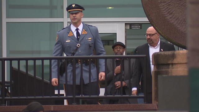 A New Jersey state trooper and mayors exit the state police headquarters 