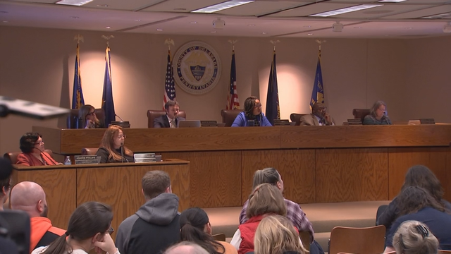 Councilmembers and audience members listen during a council meeting 