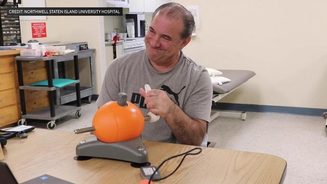 A stroke survivor performs arm exercises with a physical therapist. 