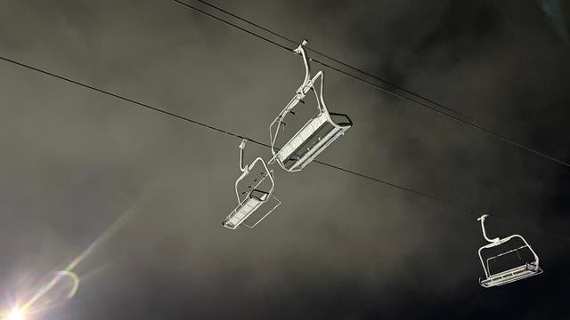 Ski And Snowboard Resort Metal Chairlifts Up In The Dark Sky, Lit Up In Bright Light At Night With Foggy Clouds, At Boreal Ski Resort Soda Springs California 