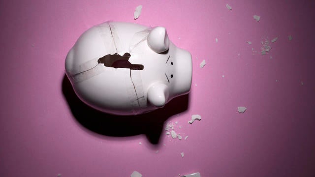 A broken piggy bank with pieces taped back together 