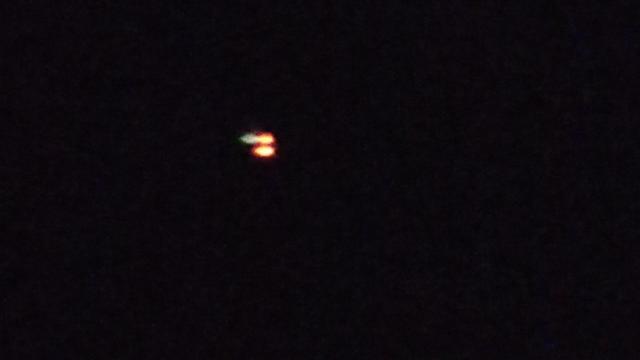 A flying object with orange lights. 