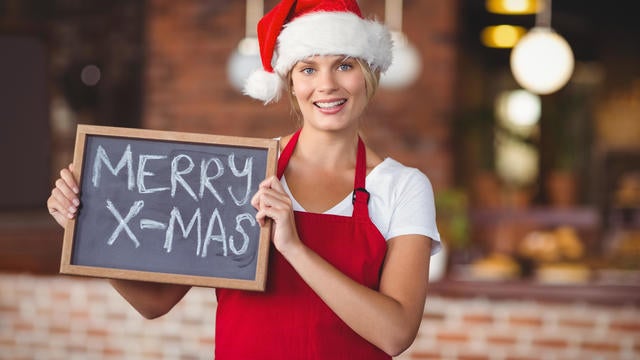 Pretty waitress with a chalkboard merry x-mas 