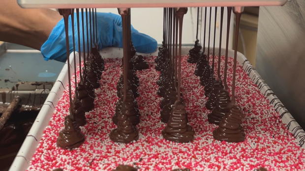 Chocolate is poured into a pan of sprinkles to make candies at Giambri's 