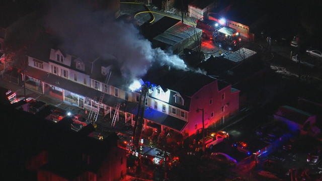 Chopper footage shows emergency vehicle lights as crews fight a fire at rowhomes in Allentown, smoke is coming out of the buildings 