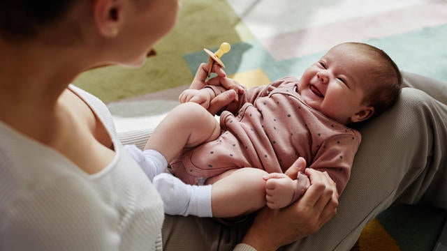 Laughing Baby Girl on Mothers Lap 