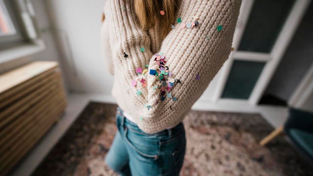 Confetti on woman's arm at home 