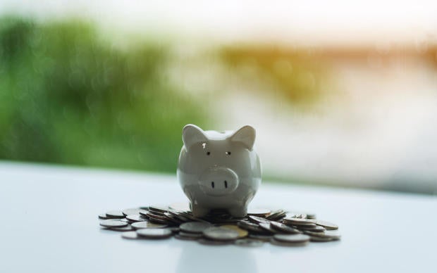 a piggy bank on pile of coins for saving money concept 