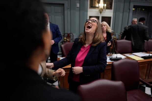 Sarah McBride throws her head back with laughter with other lawmakers in the Delaware Senate 