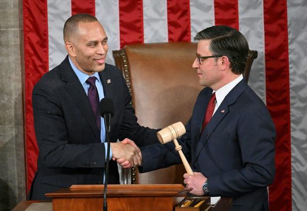 House Minority Leader Hakeem Jeffries shakes hands with Speaker of the House Mike Johnson during the first day of the 119th Congress in the House chamber on Jan. 3, 2025. 