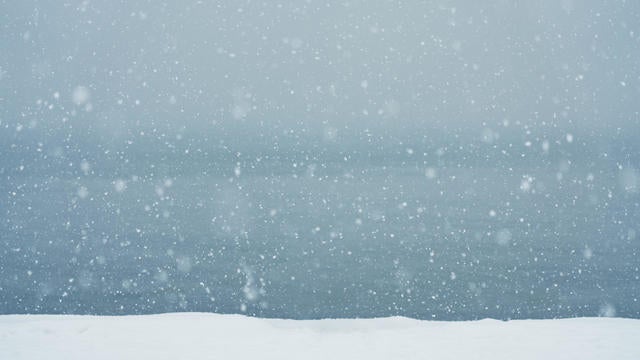 Falling Snowflakes against sky 