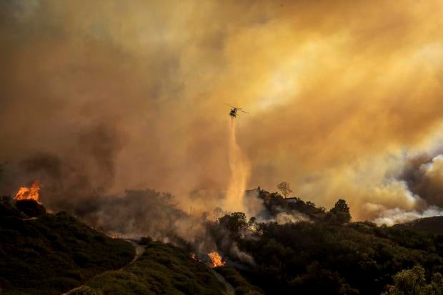 Water is dropped on the advancing Palisades Fire by helicopter on Jan. 7, 2025. 