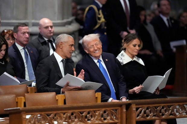 Former President Barack Obama talks with President-elect Donald Trump at former President Jimmy Carter's funeral at Washington National Cathedral on Thursday, Jan. 9, 2025. 