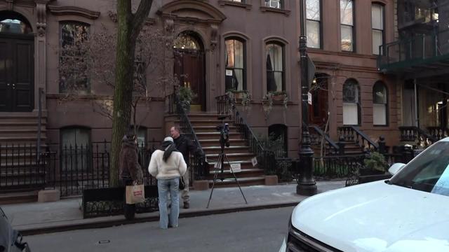 The exterior of a brownstone featured in "Sex and the City." The stoop has a chain across the bottom of the staircase, along with a "no trespassing" sign. 