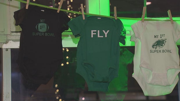 Eagles onesies hang on a clothesline at Threadwell