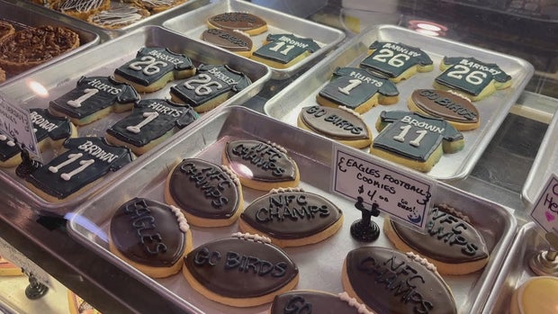 Cookies decorated like Eagles jerseys and footballs fill trays at a bakery