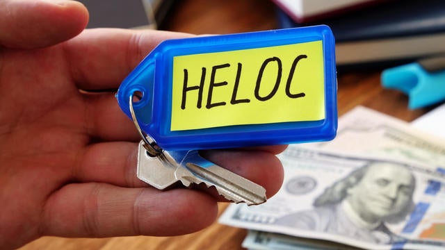 Heloc loan concept. Hand holds key as symbol of property buying. 