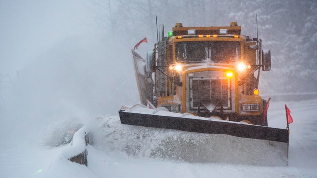 Snowplow plowing the highway during snow storm. 