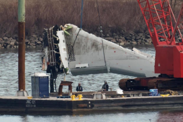 A crane retrieves a wing from the wreckage of American Eagle Flight 5342 in the Potomac River following the deadly midair collision with a Black Hawk helicopter, by Ronald Reagan Washington National Airport, in Arlington, Virginia, Feb. 3, 2025. 