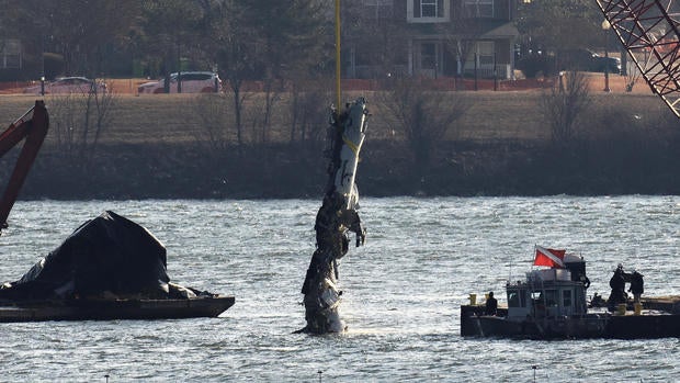 A crane retrieves part of the wreckage from the Potomac River, in the aftermath of the collision of American Eagle Flight 5342 and a Black Hawk helicopter, by Ronald Reagan Washington National Airport, in Arlington, Virginia, Feb. 4, 2025. 