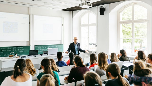 University Professor Addressing His Pupils During Lecture
