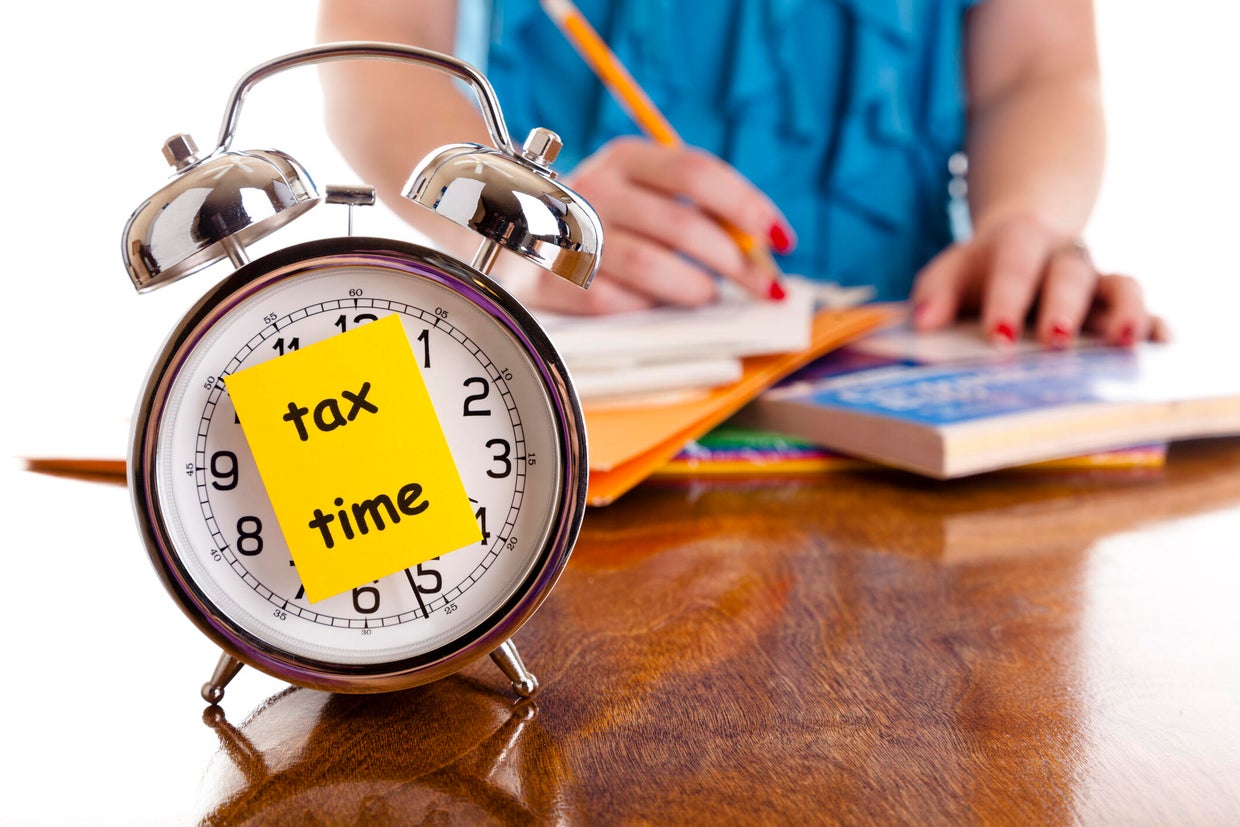 Time:  Alarm clock, income tax time note.  Woman background. Reminder. 