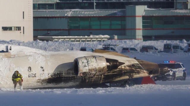 An emergency responder works around an aircraft on a runway, after a plane crash at Toronto Pearson International Airport in Mississauga 