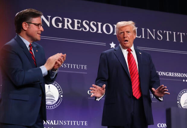 President Trump acknowledges the crowd as House Speaker Mike Johnson looks on before addressing the 2025 Republican Issues Conference at the Trump National Doral Miami on Jan. 27, 2025, in Doral, Florida.