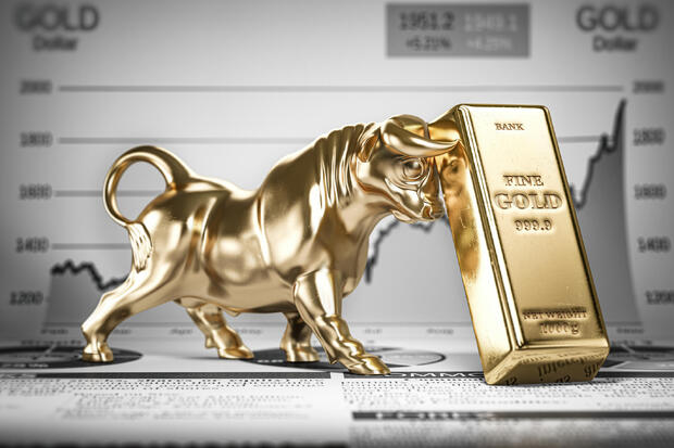 Golden ingot and bull on graph.  Bull market trend in gold. 