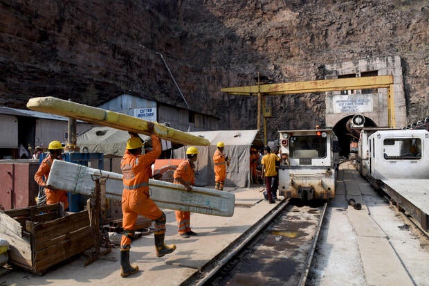 Anggota tim NDRF membawa peralatan mereka selama operasi penyelamatan di luar terowongan kanal Srisailam Left di Nagarkurnool 