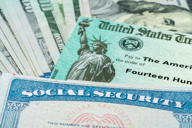 Illustration of the 2021 federal stimulus check from the IRS with cash and social security card 