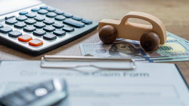 Car insurance concept with calculator on wood table 