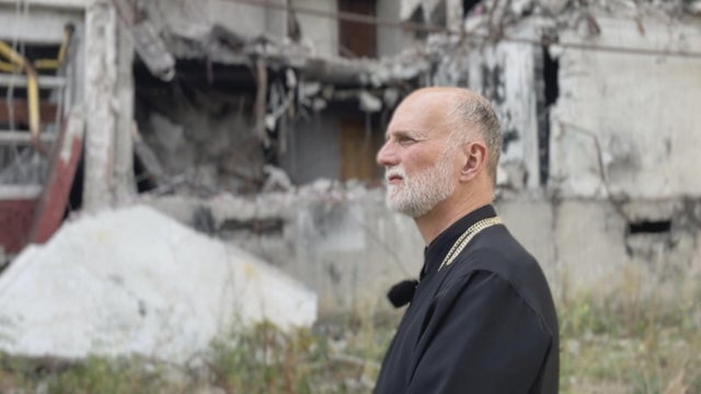 The archbishop is seen amid rubble in Ukraine