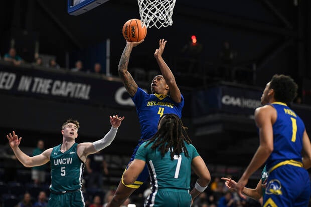 Delaware guard Niels Lane (4) shoots the ball over UNC Wilmington guard Greedy Williams (7) during the first half of an NCAA college basketball game in the championship of the Coastal Athletic Association tournament 