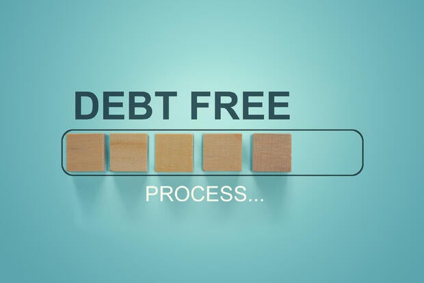 Finance conceptual, Business concept: Woodblocks with the word Debt Free in the loading bar progress. Depicts repayment planning and money management. To increase financial liquidity to pay off debt. 